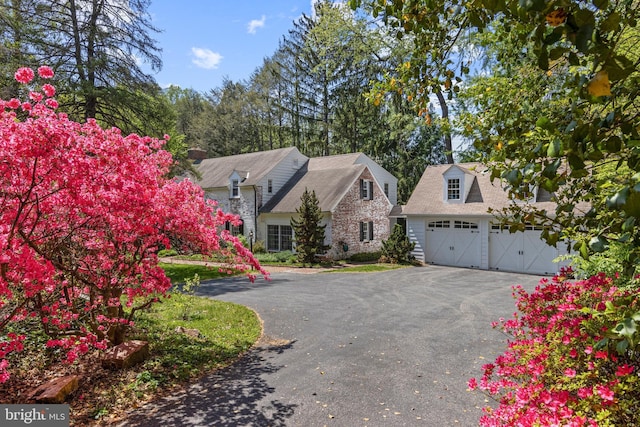 view of front of property with stone siding and asphalt driveway