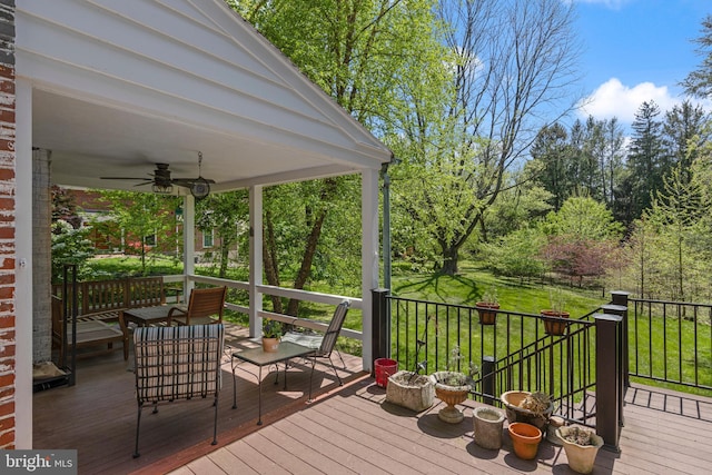 wooden deck featuring ceiling fan and a yard