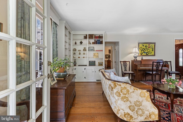 living area featuring wood finished floors, crown molding, and french doors