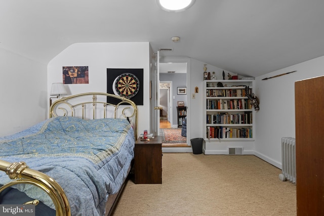 bedroom with vaulted ceiling, radiator, and carpet floors