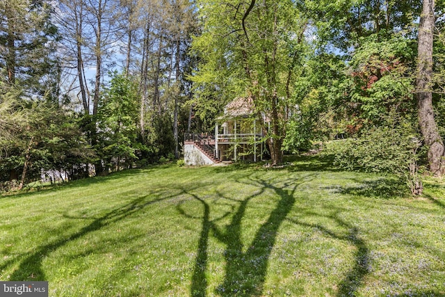 view of green lawn featuring stairway