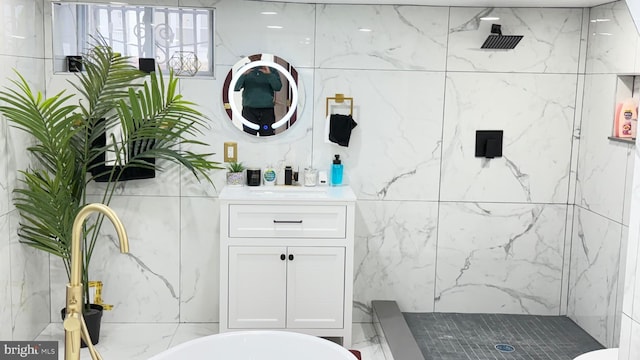 full bath featuring a marble finish shower and vanity