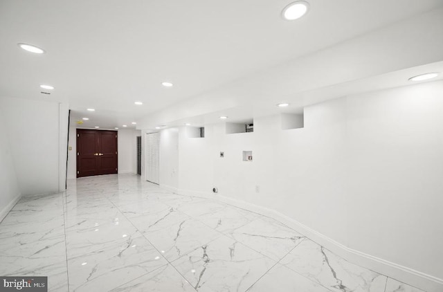 interior space with baseboards, recessed lighting, and marble finish floor