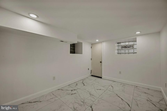 finished basement featuring baseboards, recessed lighting, and marble finish floor