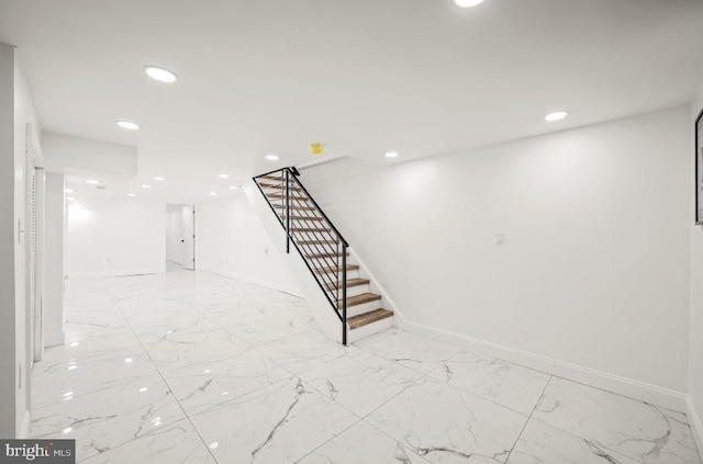 interior space featuring recessed lighting, marble finish floor, and baseboards