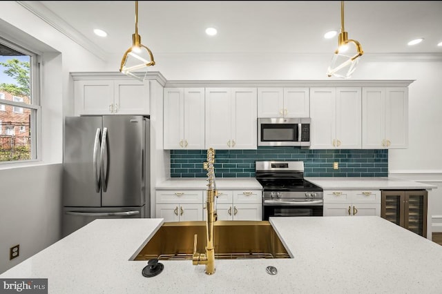 kitchen featuring a sink, beverage cooler, stainless steel appliances, backsplash, and pendant lighting