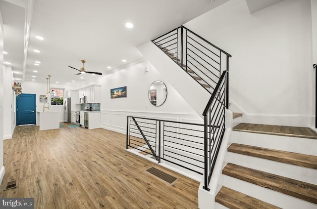 staircase with visible vents, recessed lighting, ceiling fan, and wood finished floors