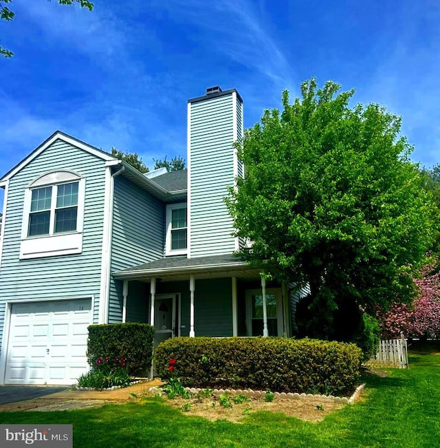 view of front facade featuring an attached garage, a chimney, and a front yard