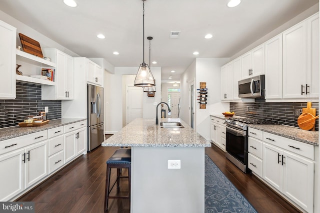 kitchen with a sink, white cabinetry, decorative backsplash, and stainless steel appliances