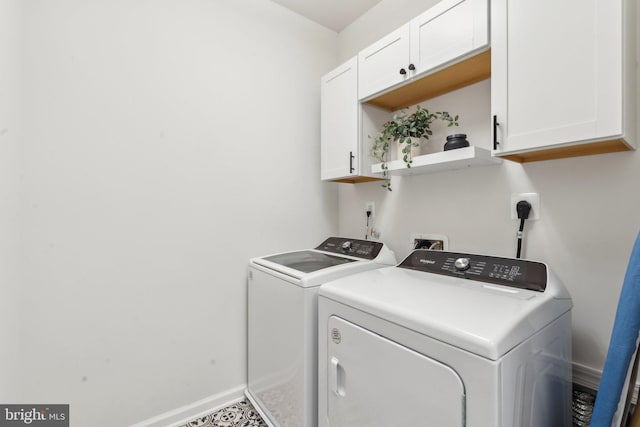 laundry room with baseboards, washer and clothes dryer, and cabinet space