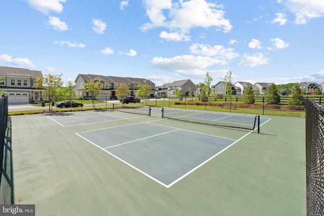 view of sport court featuring fence, community basketball court, and a residential view