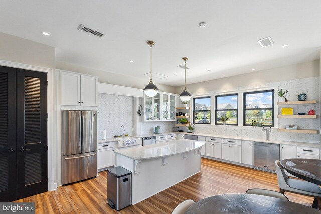 kitchen with appliances with stainless steel finishes, open shelves, backsplash, and visible vents