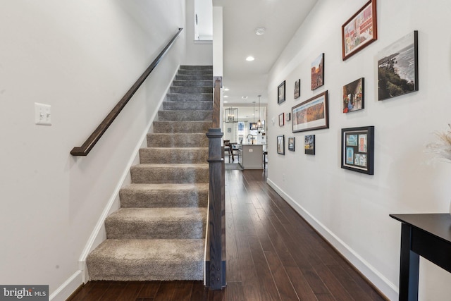 stairs featuring recessed lighting, baseboards, hardwood / wood-style flooring, and a chandelier