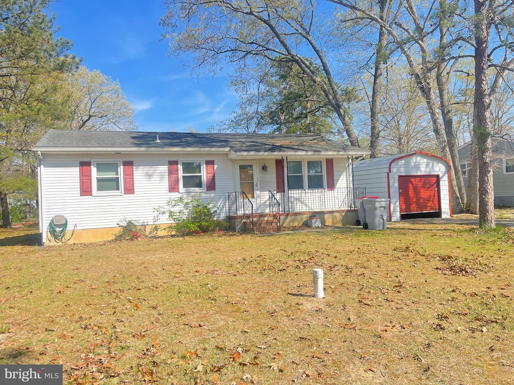 ranch-style house featuring a storage shed, a front lawn, an outbuilding, and a detached garage
