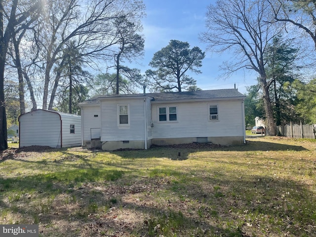 back of property with a yard, crawl space, and fence