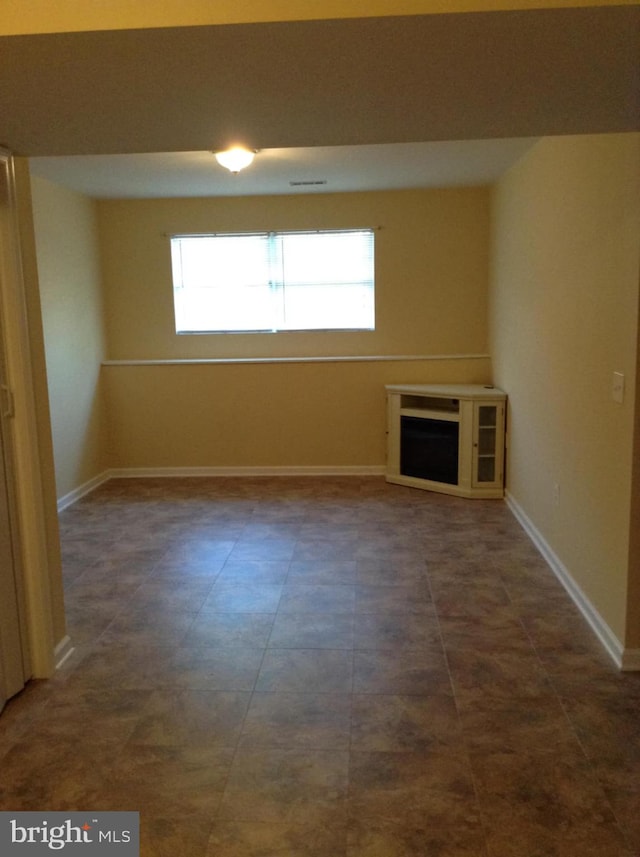 unfurnished living room with baseboards and a fireplace