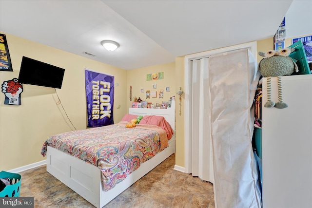 bedroom with stone finish flooring, baseboards, and visible vents
