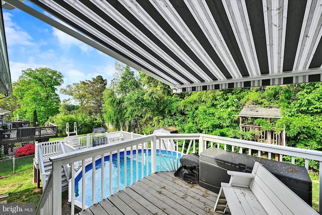 wooden terrace with a fenced backyard and an outdoor pool