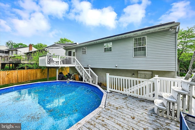 view of pool with stairway, fence, a fenced in pool, and a wooden deck