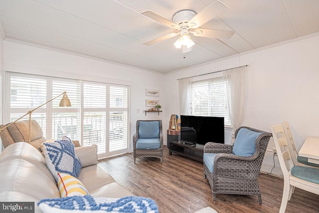 living area with ornamental molding, plenty of natural light, and wood finished floors