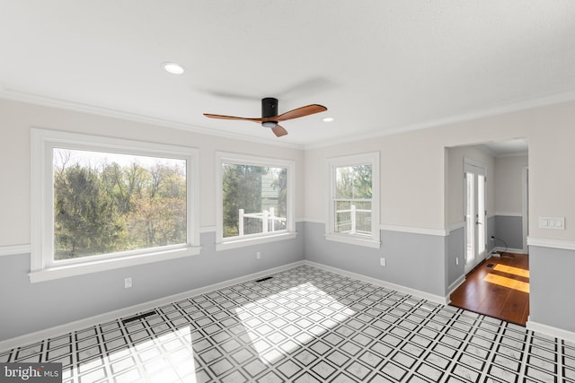 spare room featuring baseboards, a ceiling fan, and crown molding