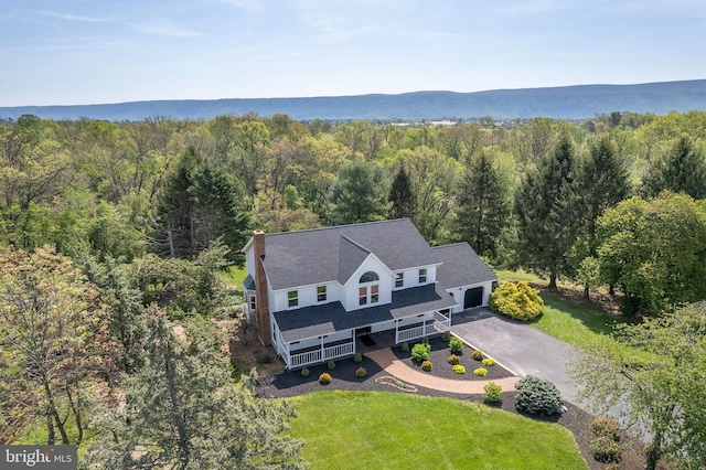 drone / aerial view featuring a wooded view