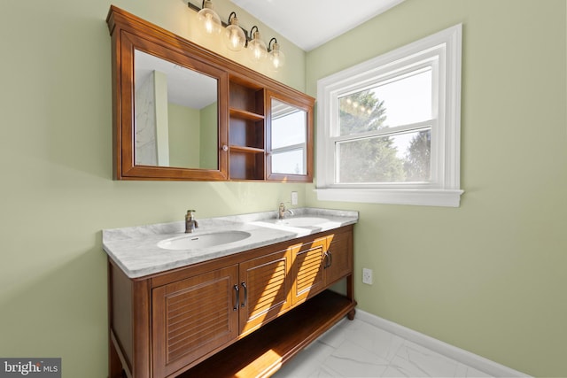 bathroom with double vanity, a sink, baseboards, and marble finish floor
