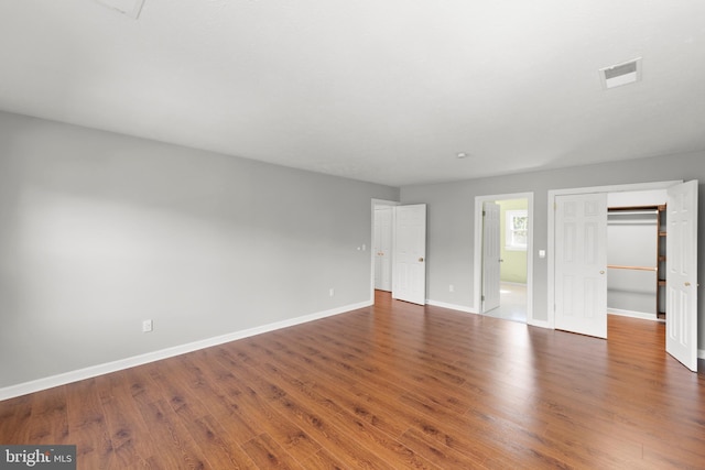interior space with baseboards, visible vents, and wood finished floors