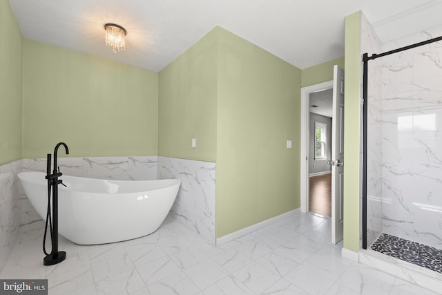 full bath with wainscoting, a marble finish shower, a soaking tub, and marble finish floor