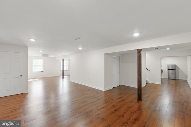 basement with recessed lighting, freestanding refrigerator, baseboards, and wood finished floors
