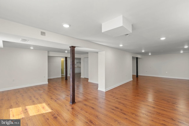 finished below grade area with recessed lighting, light wood-style floors, baseboards, and visible vents