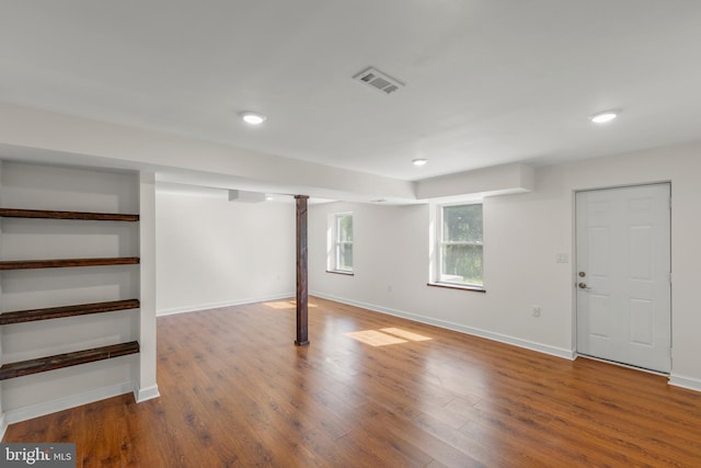 below grade area featuring recessed lighting, baseboards, visible vents, and wood finished floors