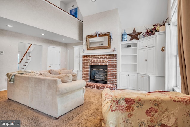 living room with recessed lighting, stairs, a brick fireplace, and high vaulted ceiling
