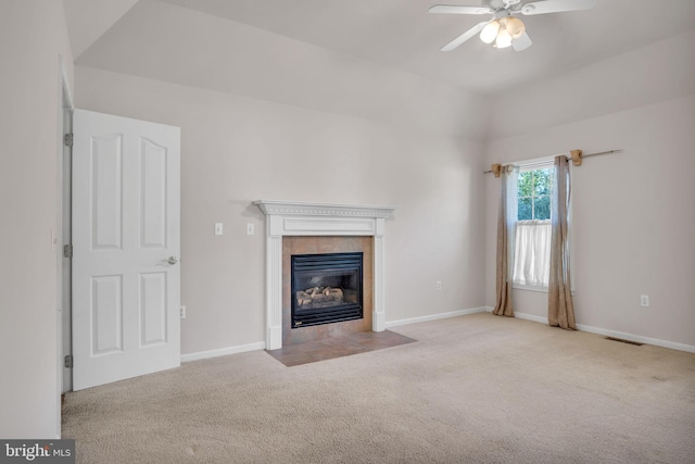 unfurnished living room with visible vents, a ceiling fan, baseboards, a tile fireplace, and carpet flooring