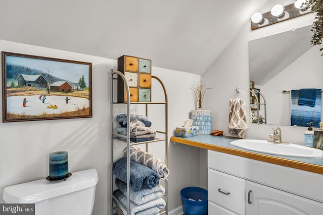 bathroom with vanity, toilet, and lofted ceiling