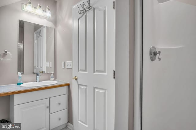 bathroom with vanity and a shower