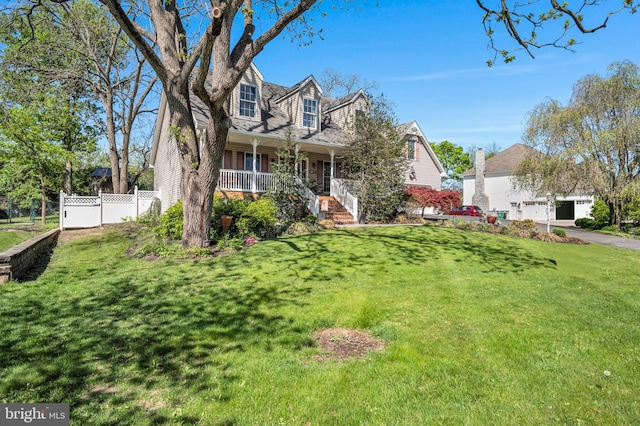 cape cod home with a garage, a front lawn, fence, and covered porch