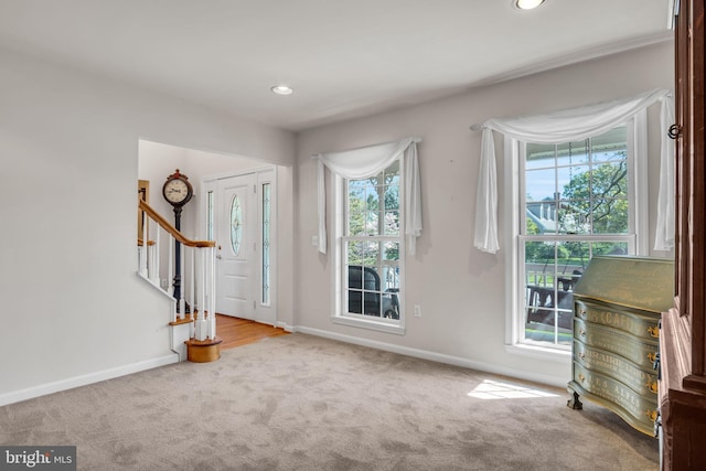 carpeted foyer entrance featuring stairs, recessed lighting, and baseboards