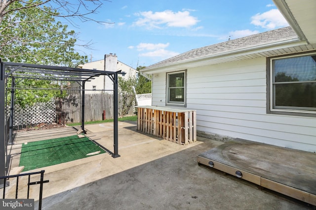 view of patio with a pergola and fence
