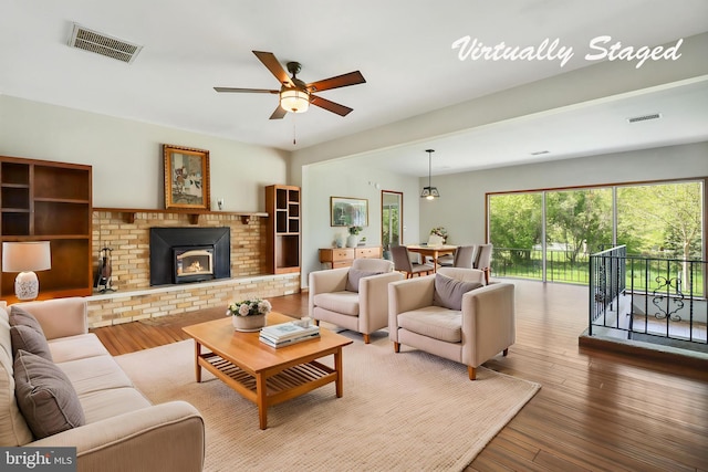 living room with wood-type flooring, a ceiling fan, and visible vents