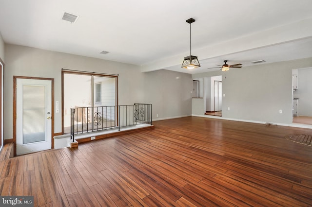 unfurnished living room featuring baseboards, a ceiling fan, hardwood / wood-style floors, and visible vents