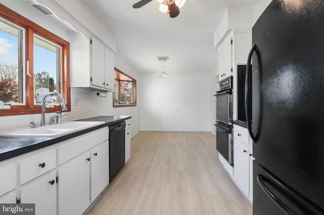 kitchen with a ceiling fan, light wood-style floors, white cabinetry, a sink, and black appliances