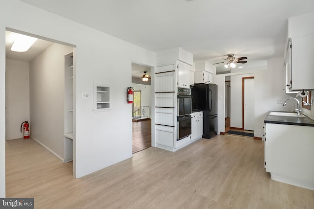kitchen featuring a sink, white cabinets, ceiling fan, and black appliances