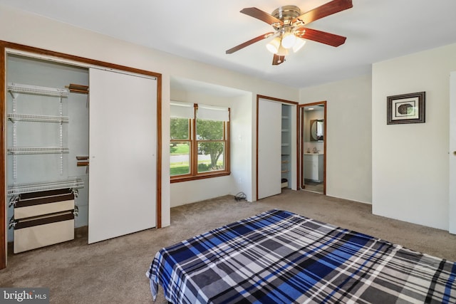 carpeted bedroom with two closets and ceiling fan