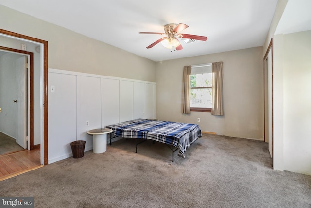 carpeted bedroom featuring ceiling fan and a closet