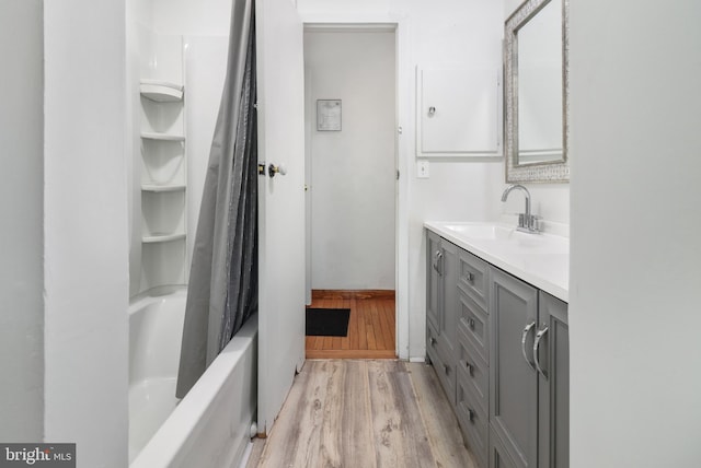 full bathroom featuring shower / bathtub combination with curtain, wood finished floors, and vanity