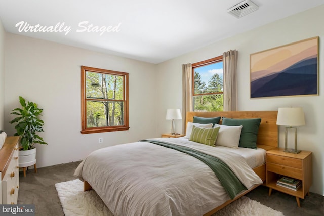 carpeted bedroom with visible vents and multiple windows