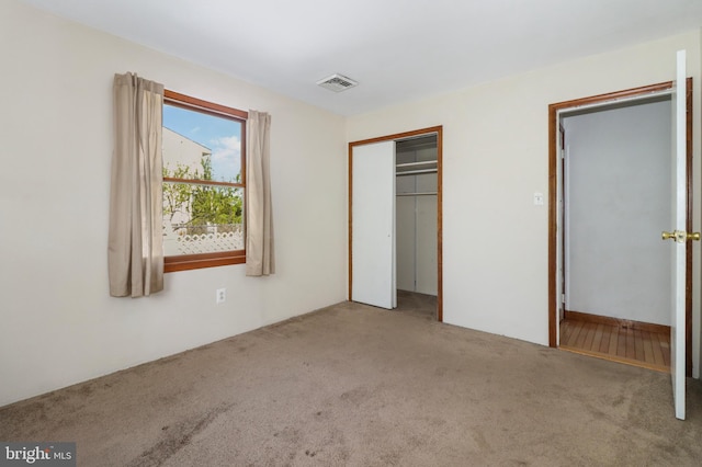 unfurnished bedroom with carpet, a closet, and visible vents