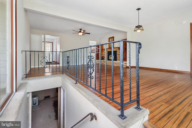 stairs featuring baseboards, a ceiling fan, and wood finished floors