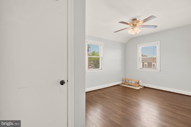 spare room featuring baseboards, ceiling fan, a wealth of natural light, and wood finished floors